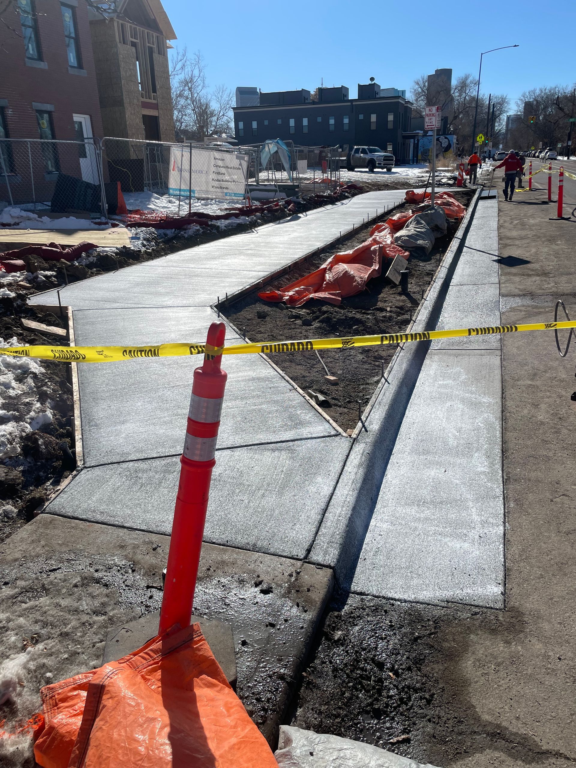 A concrete walkway is being built on the side of the road