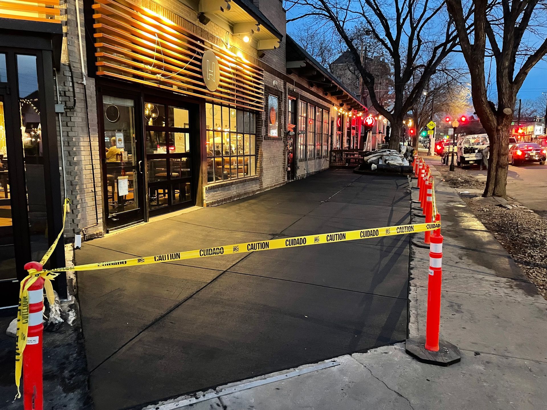 A building with a yellow tape covering the sidewalk in front of it