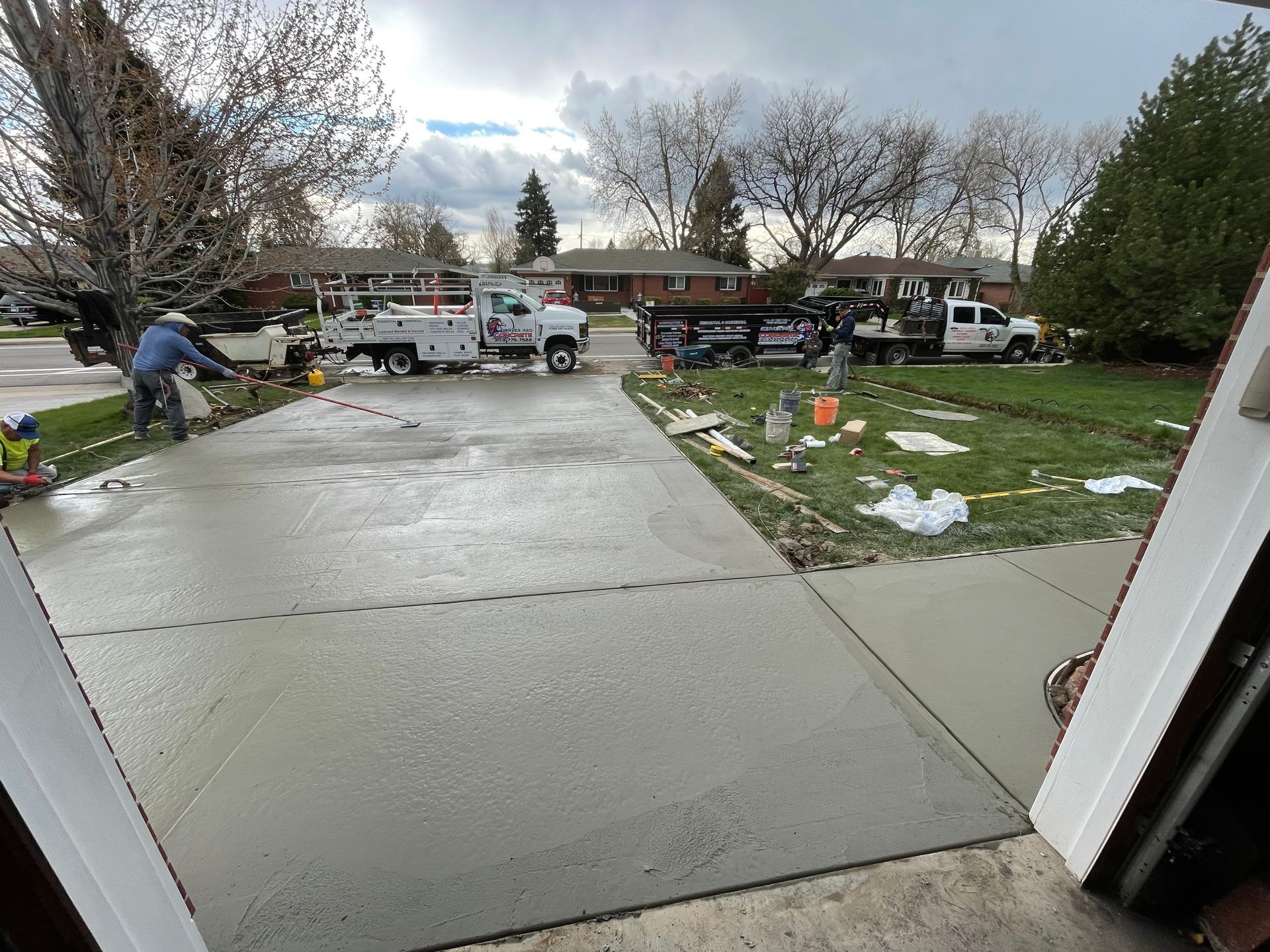 A concrete driveway is being built in a residential neighborhood.
