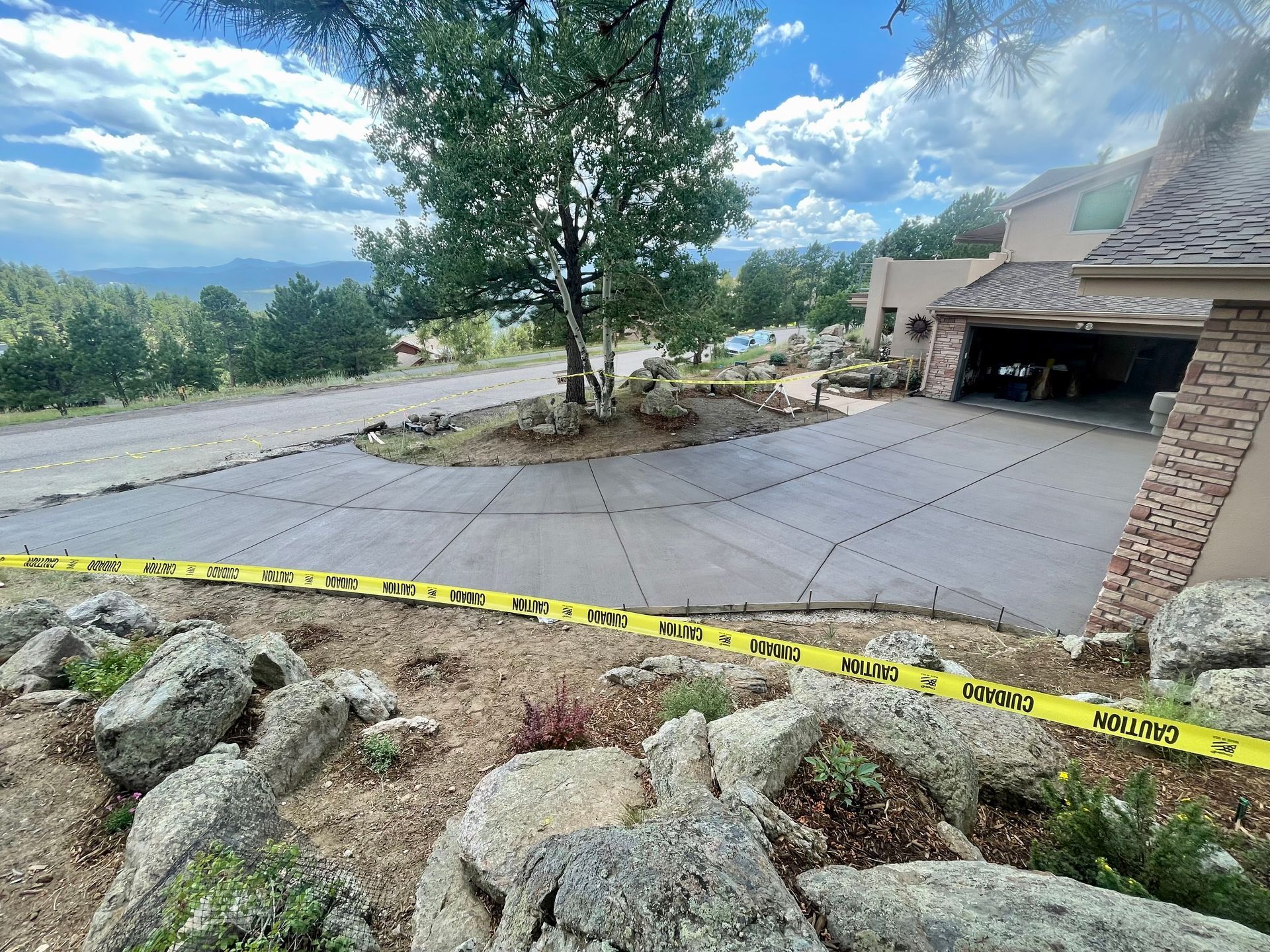 A concrete driveway is being installed in front of a house.