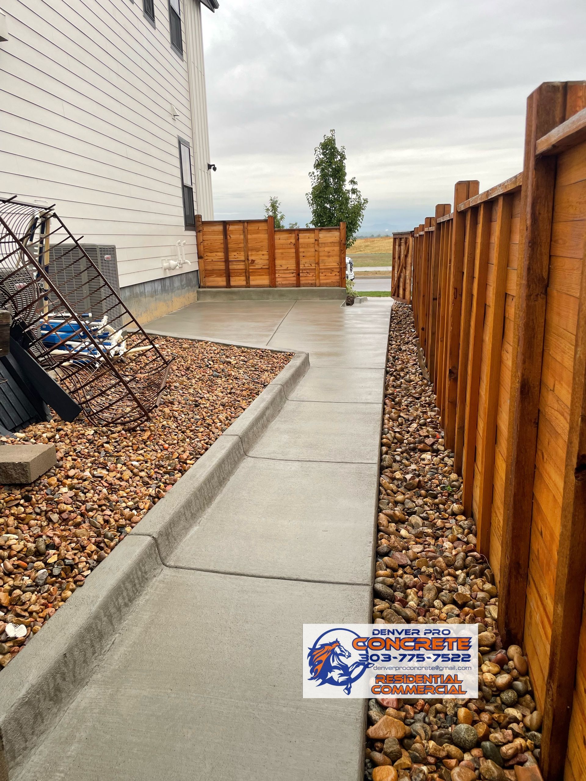 A wooden fence along a sidewalk next to a house.