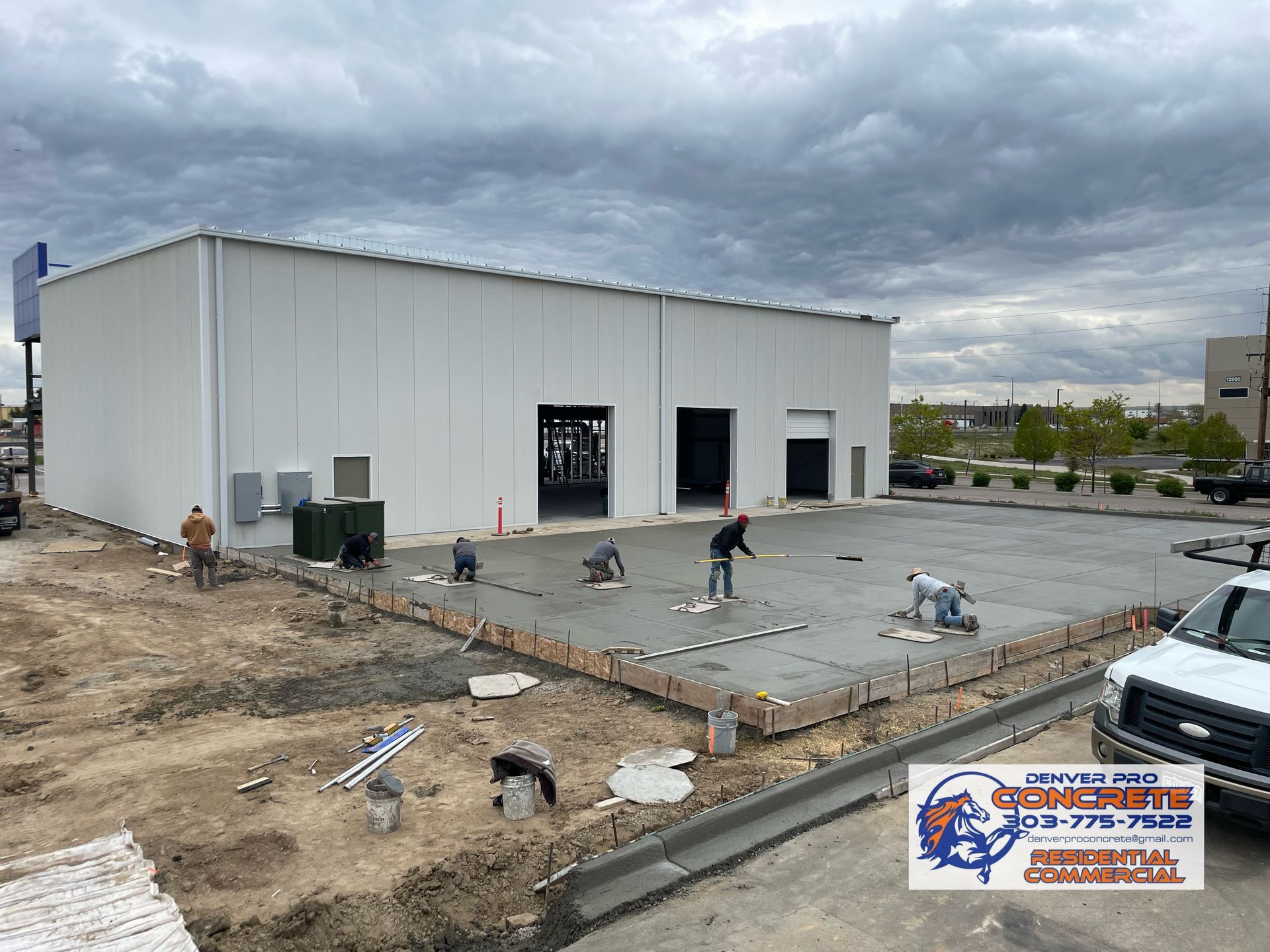 A white truck is parked in front of a building under construction.