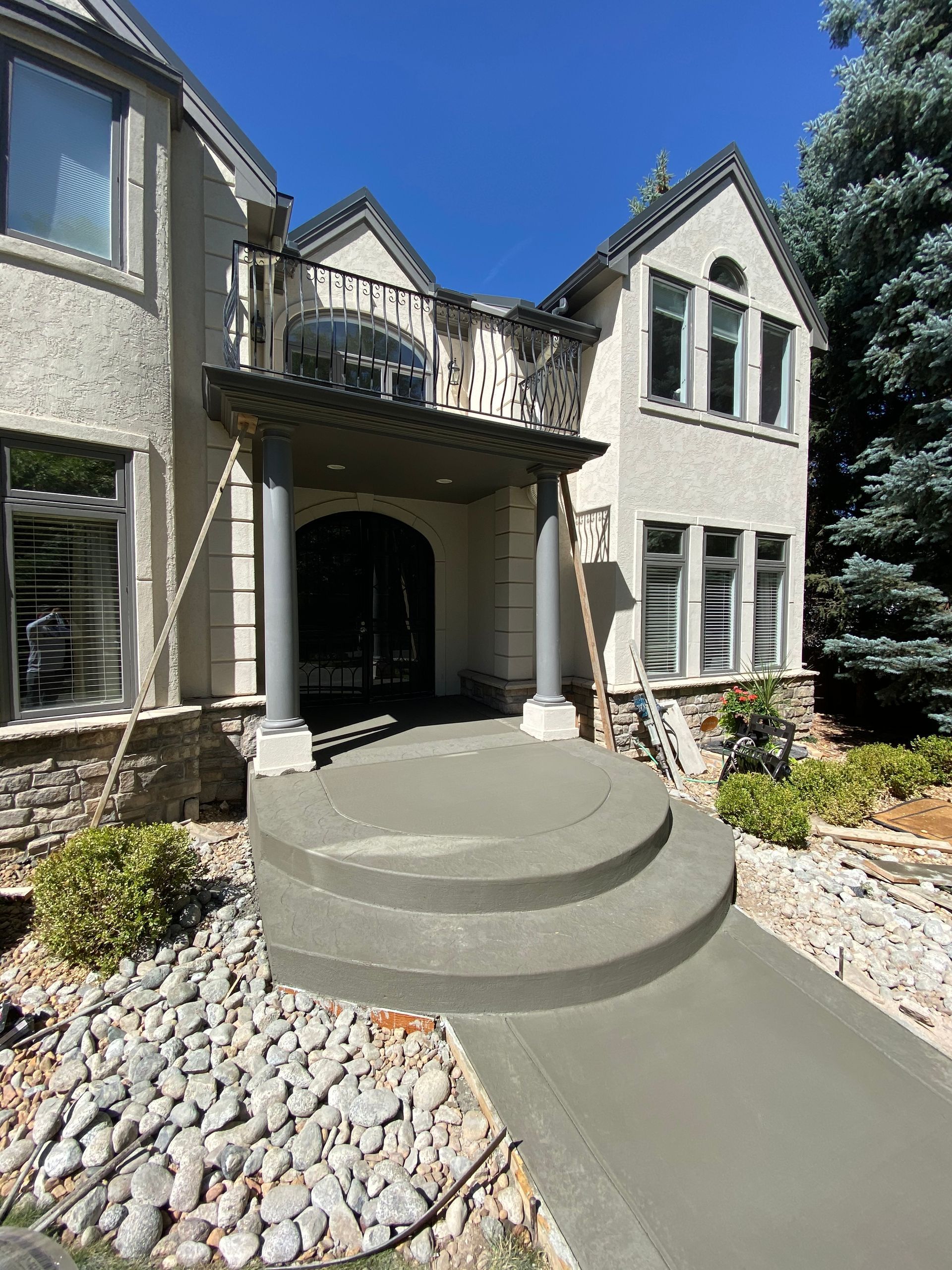 A large house with a concrete walkway leading to the front door.