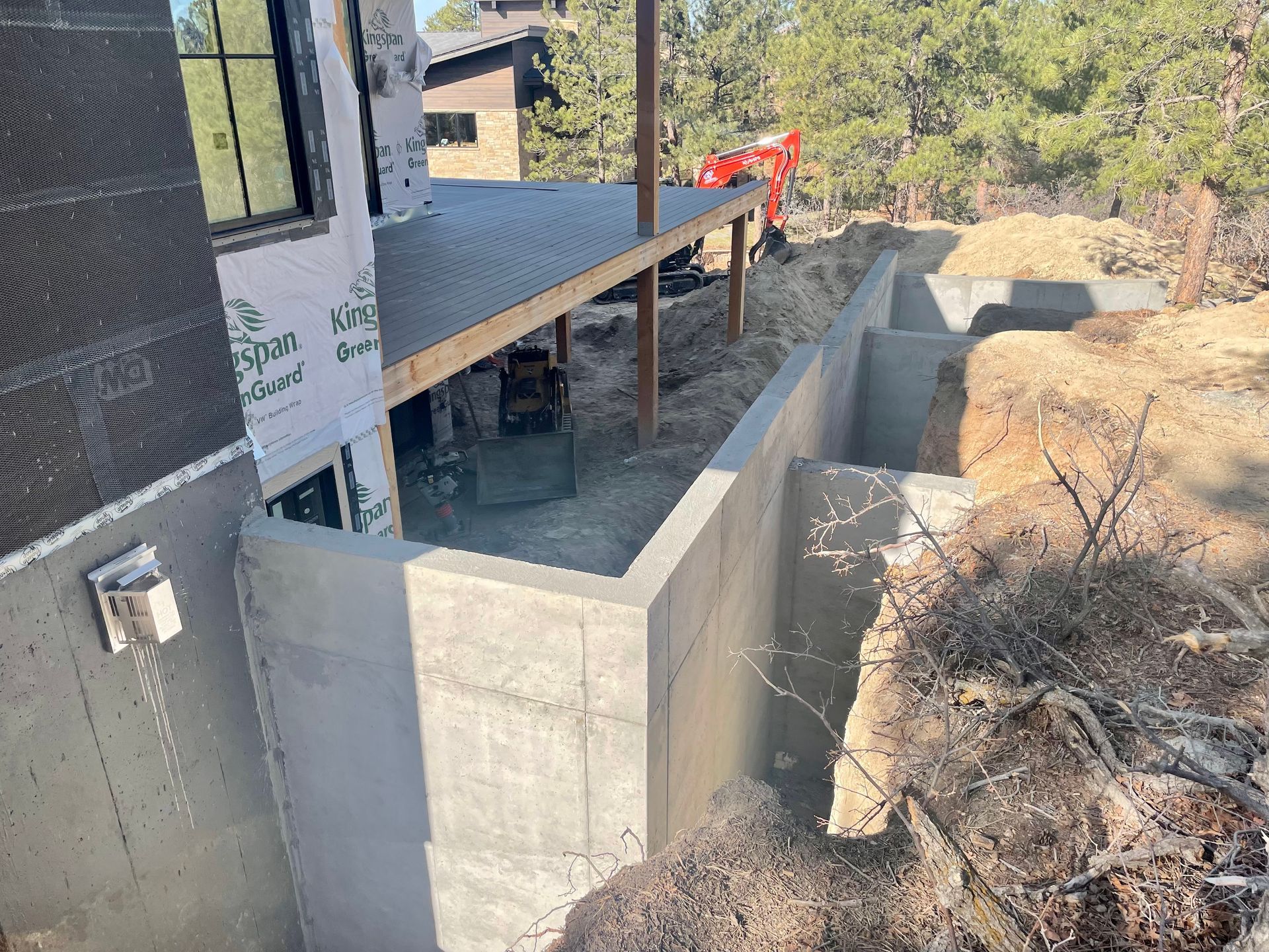 A concrete wall is being built in front of a house.