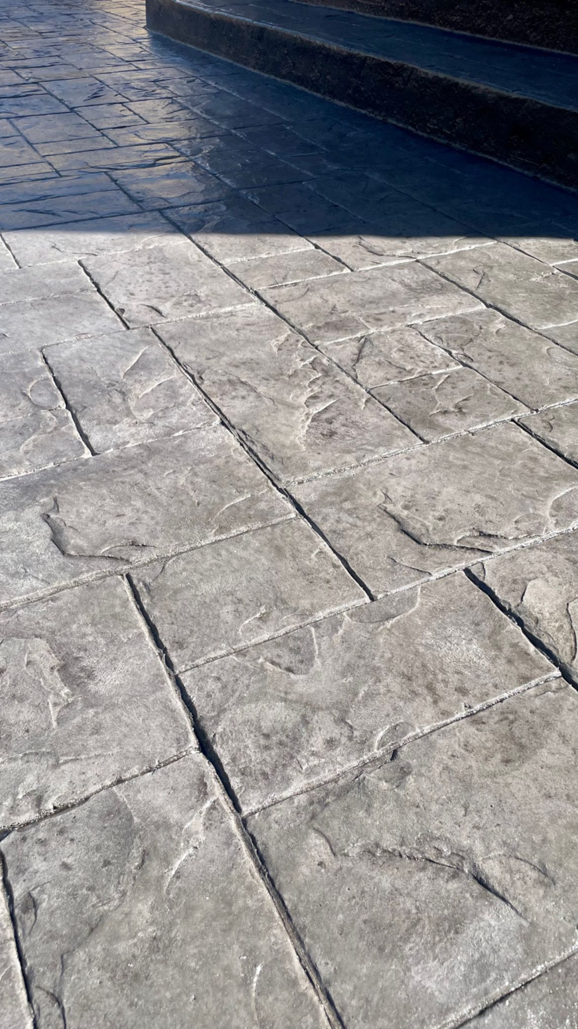 A close up of a concrete walkway next to a pool.