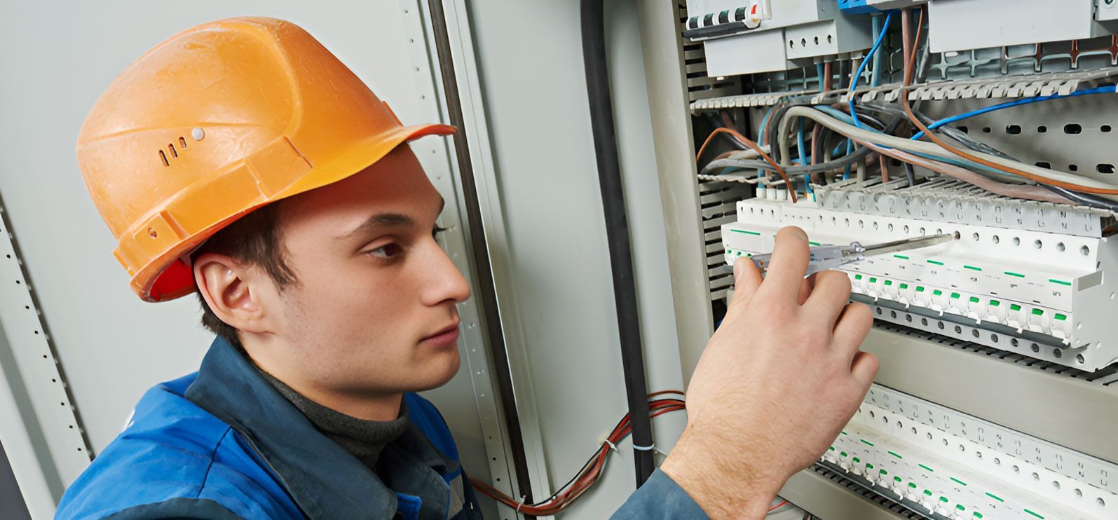 A Man Wearing A Hard Hat Is Working On An Electrical Box — Steve Mason Electrical In Port Macquarie, NSW