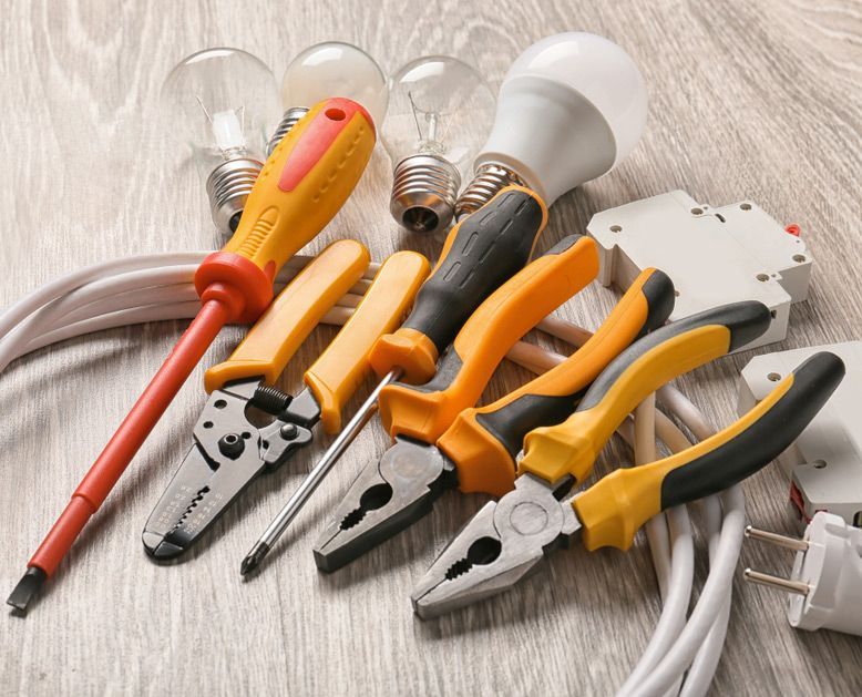 A Bunch Of Tools Are Laying On A Wooden Table — Steve Mason Electrical In Port Macquarie, NSW