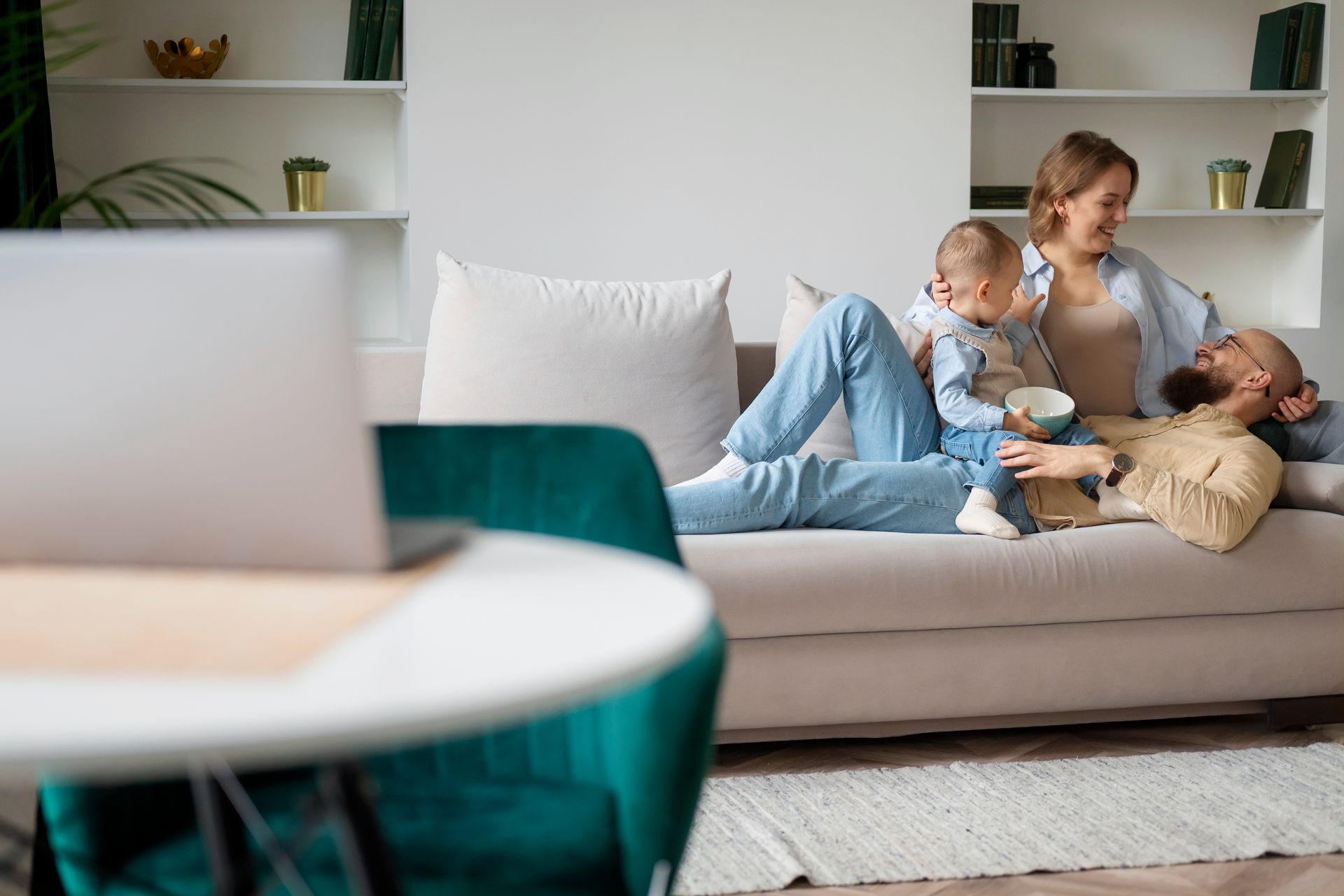 A family is sitting on a couch in a living room.