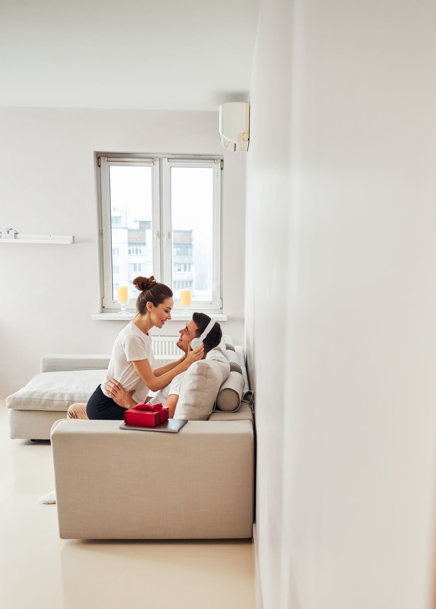 A woman is putting headphones on a man 's head in a living room.