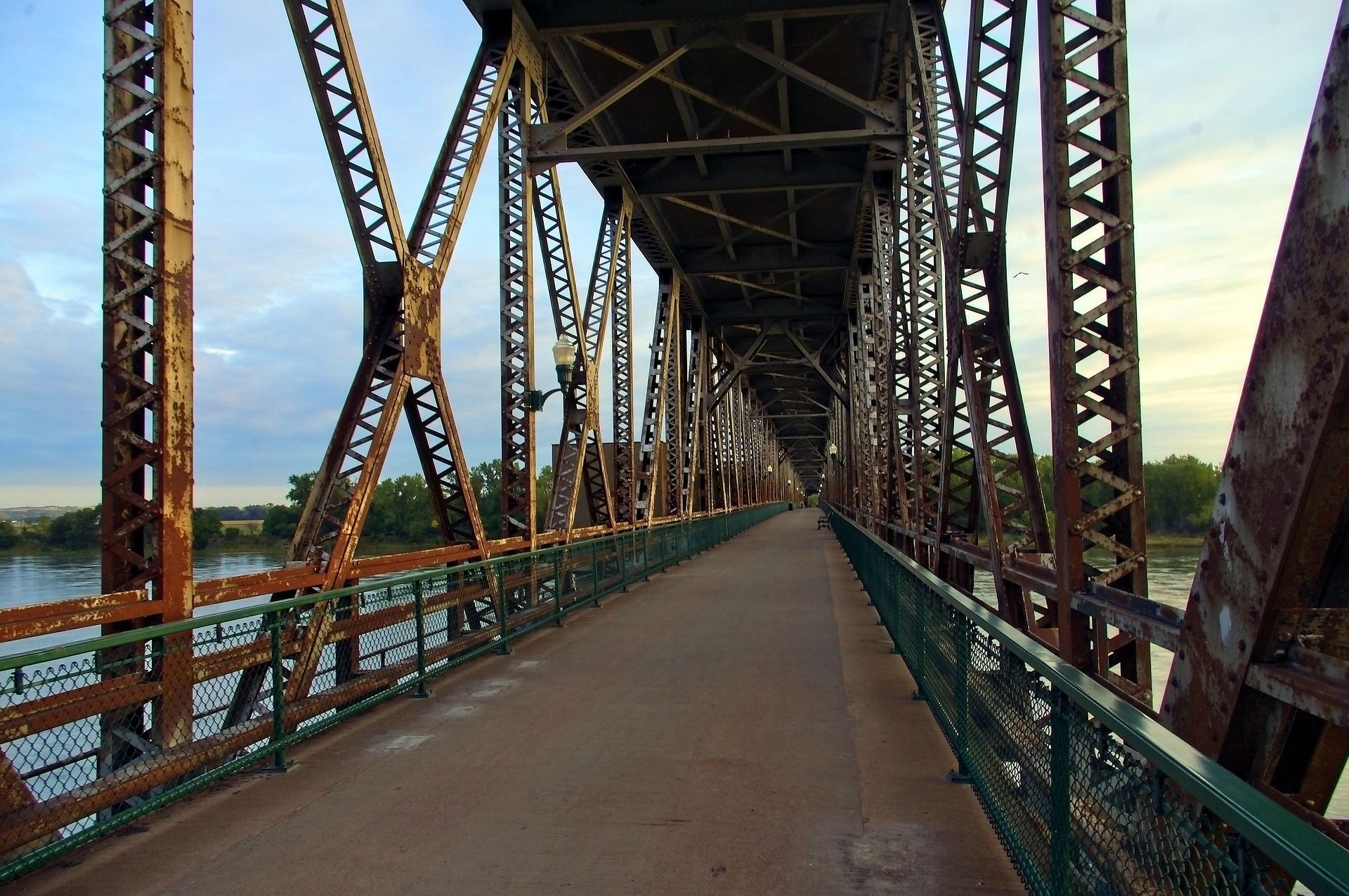 A bridge over a body of water with a green railing