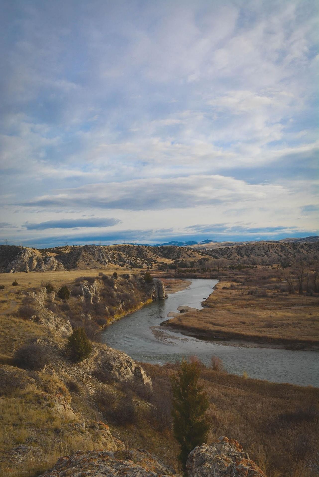 A river flowing through a valley surrounded by rocks and grass.