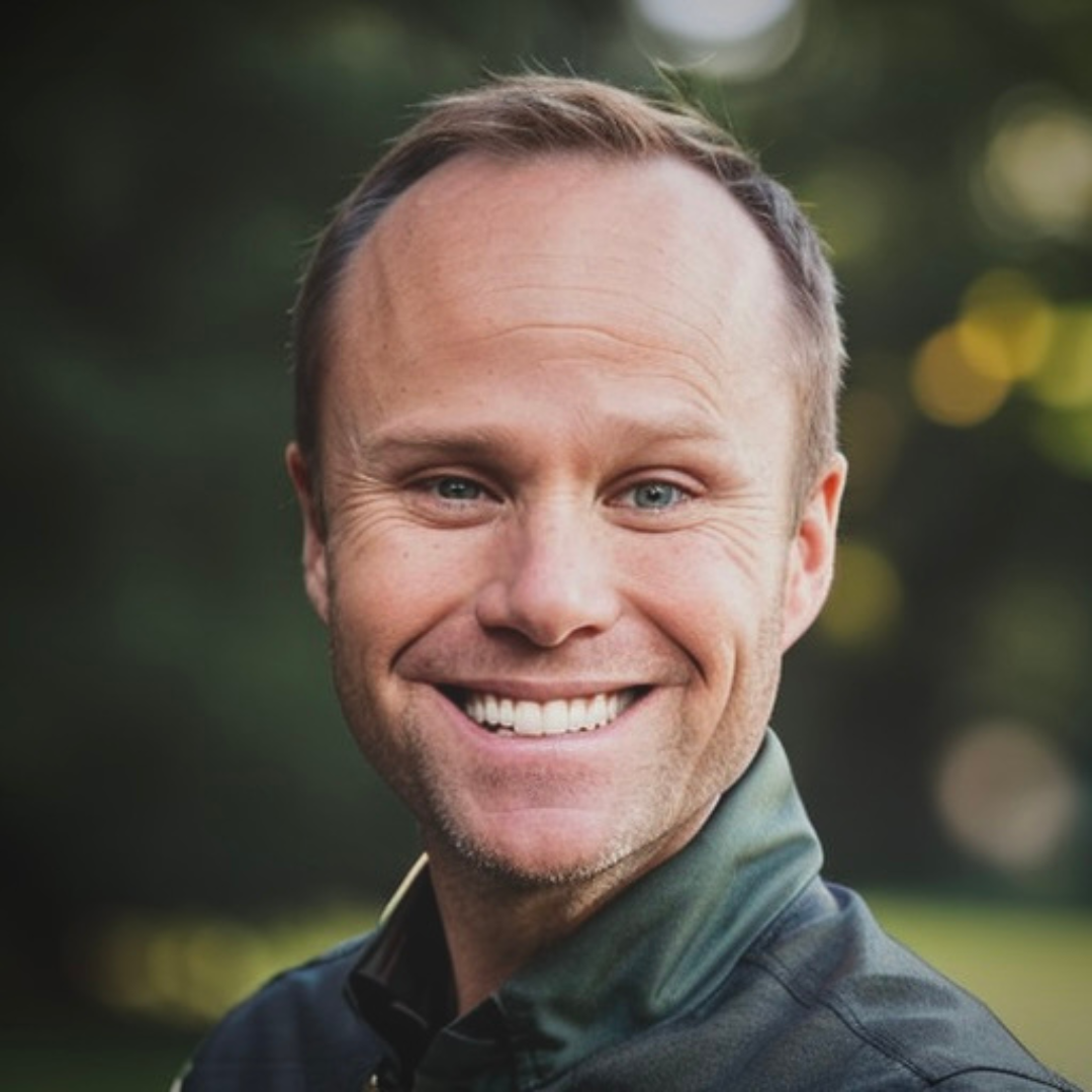 A man with a bald head is smiling for the camera