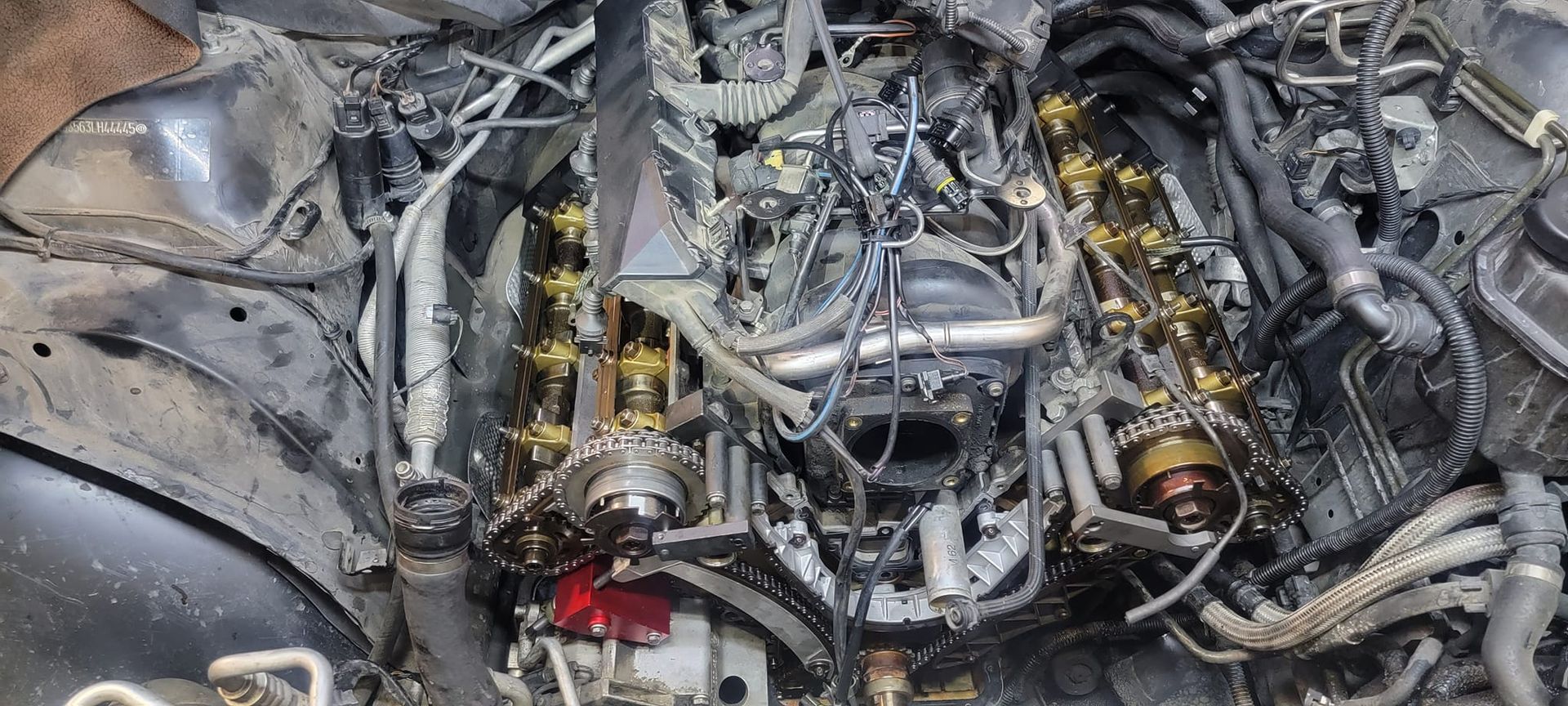 Engine with exposed components. Metallic parts, wiring, and hoses are visible.
