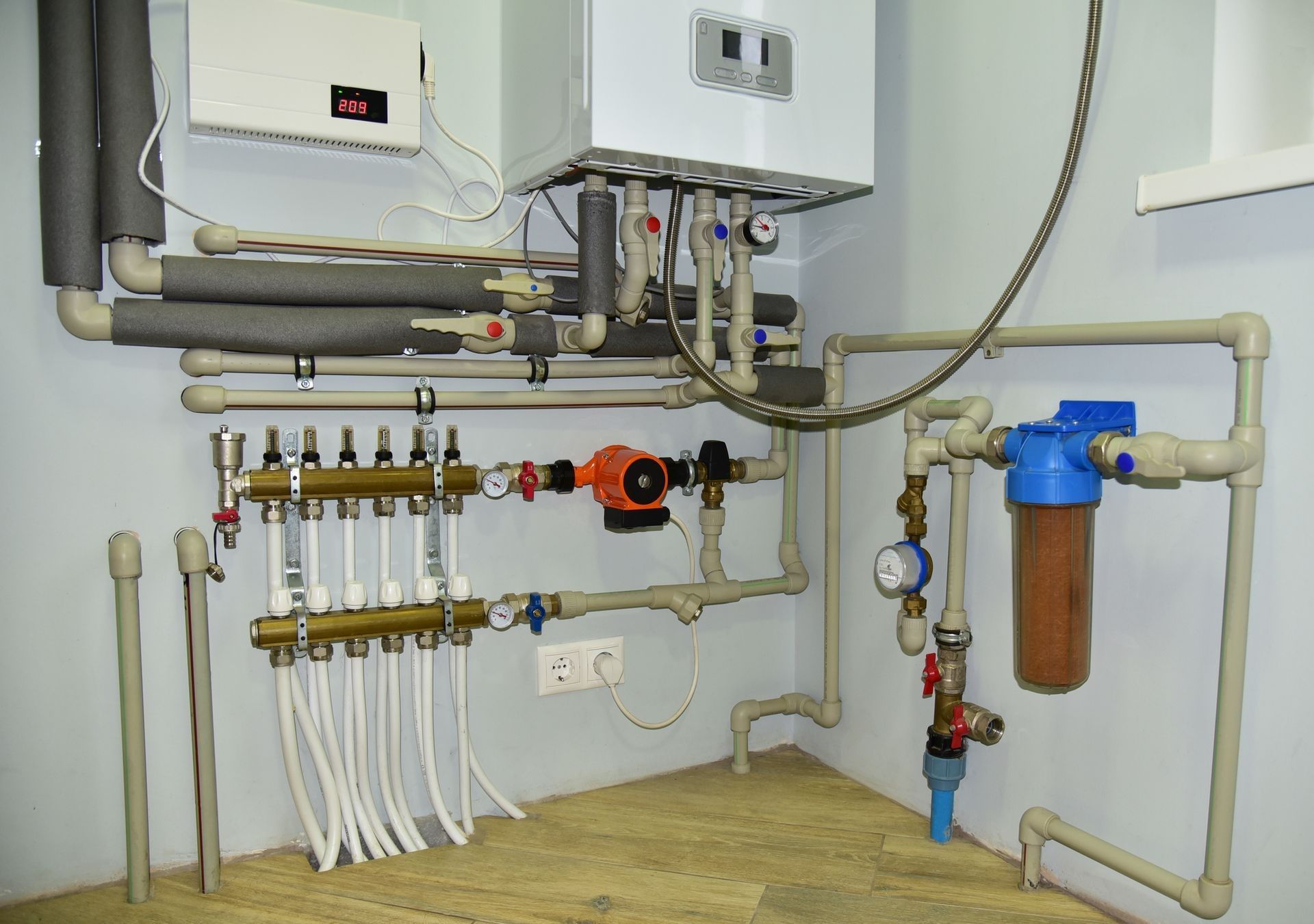 Plumbing system with a water heater, pump, filters, and pipes in a room, possibly a utility room. Plumbing system with a water heater, pump, filters, and pipes in a room, possibly a utility room.