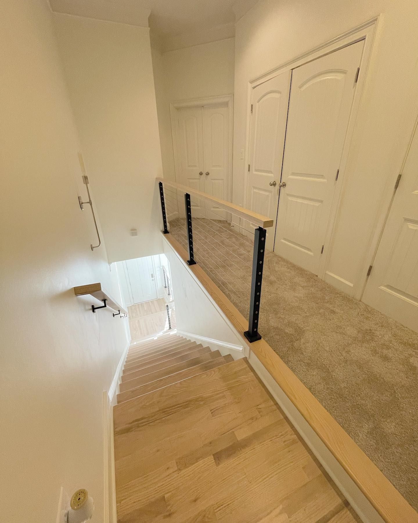 A hallway with stairs leading up to the second floor of a house.