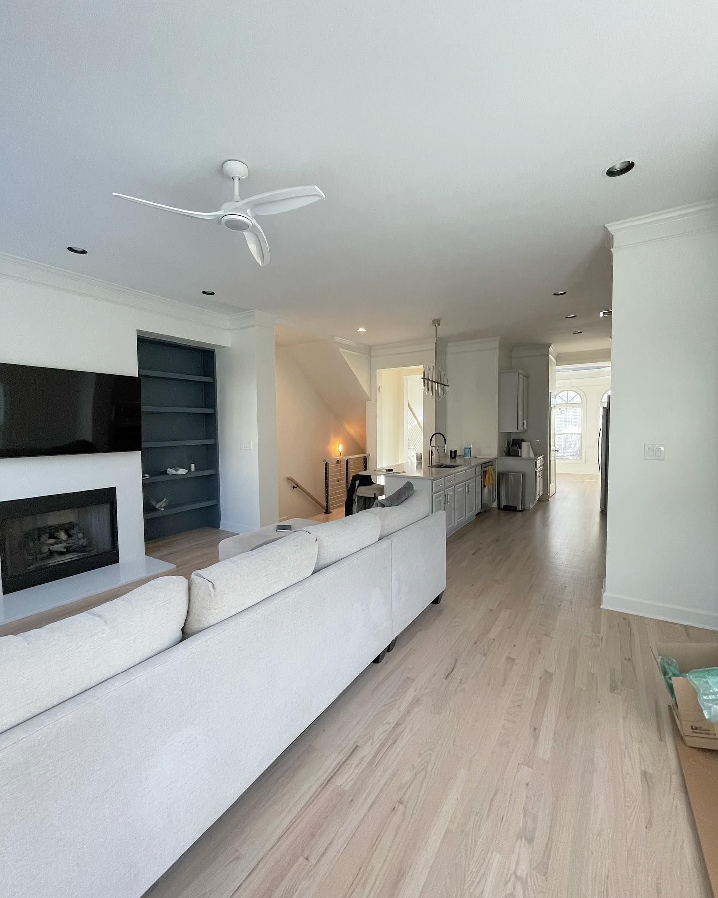 A living room with a fireplace and a ceiling fan