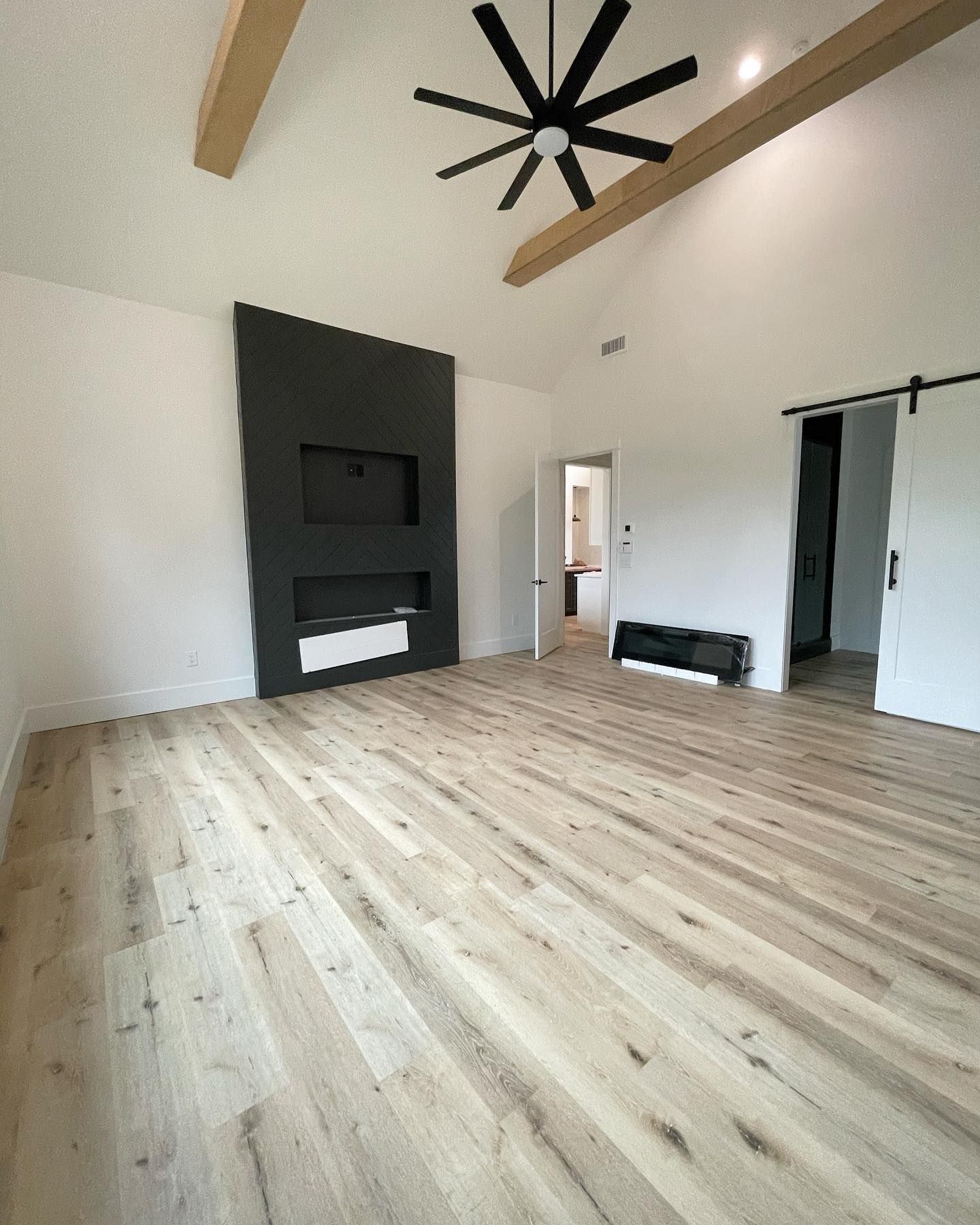 A living room with hardwood floors and a ceiling fan.