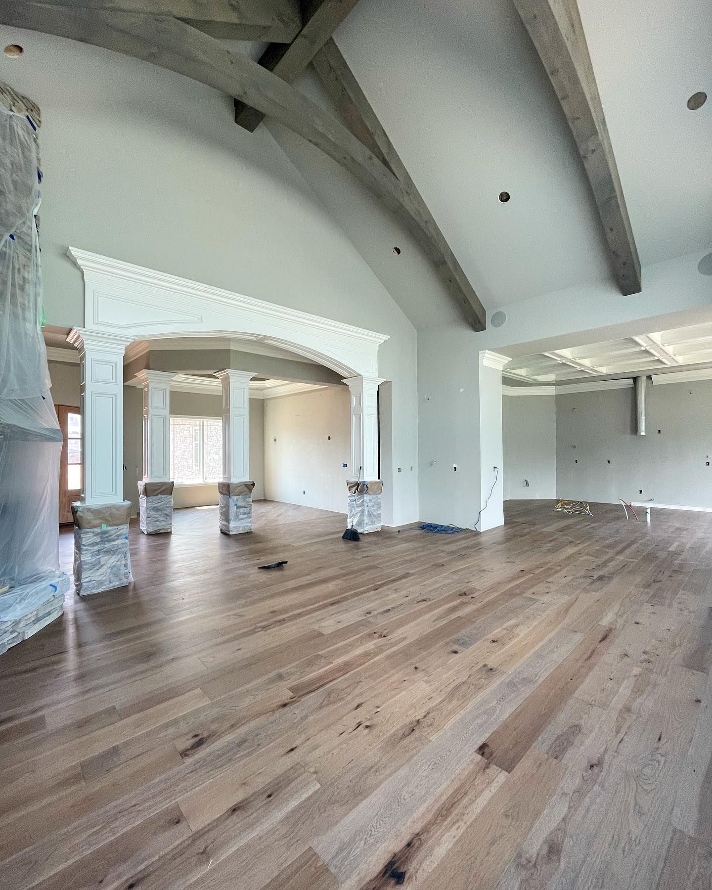 A large empty room with hardwood floors and white walls