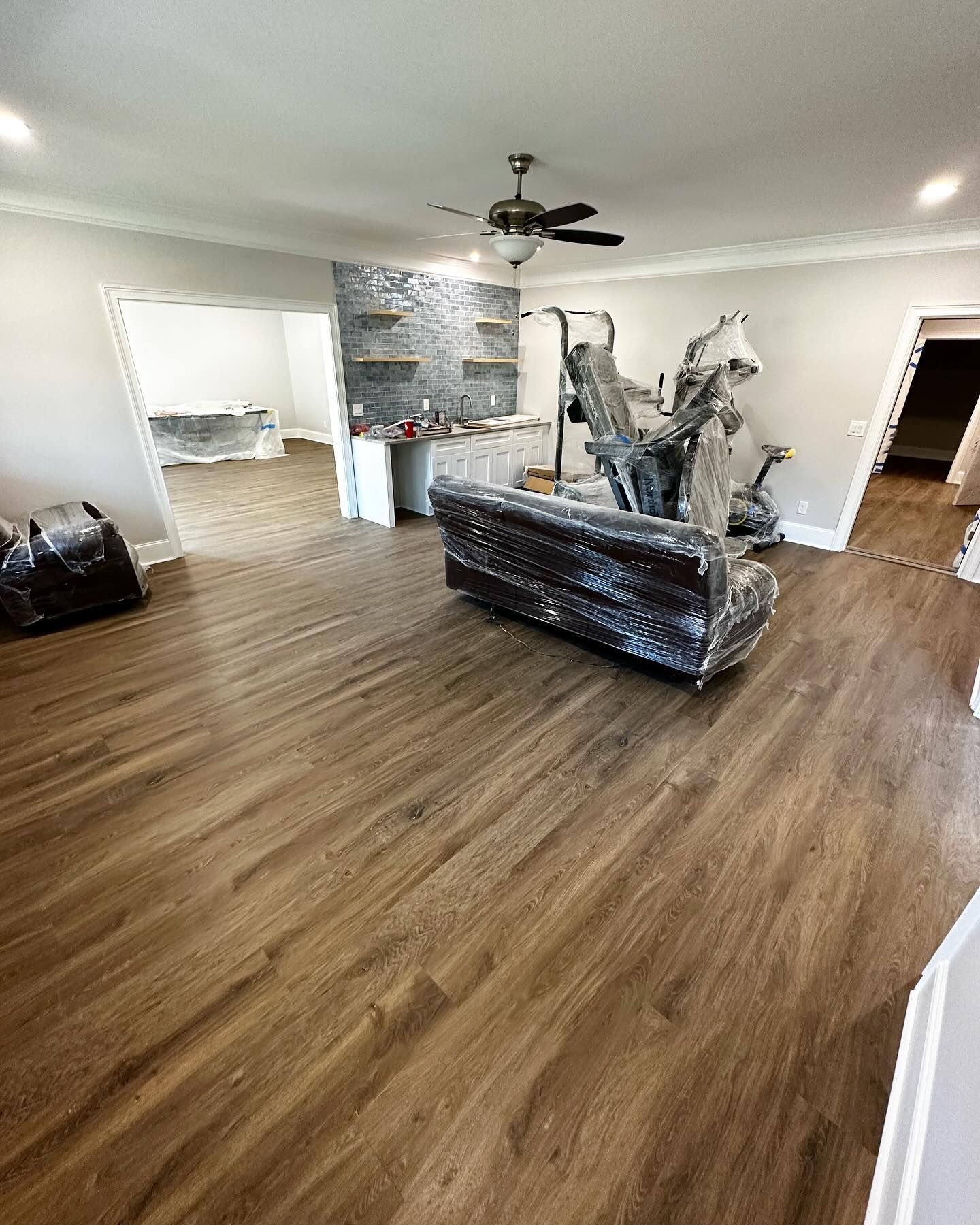 A living room with a couch and a ceiling fan.