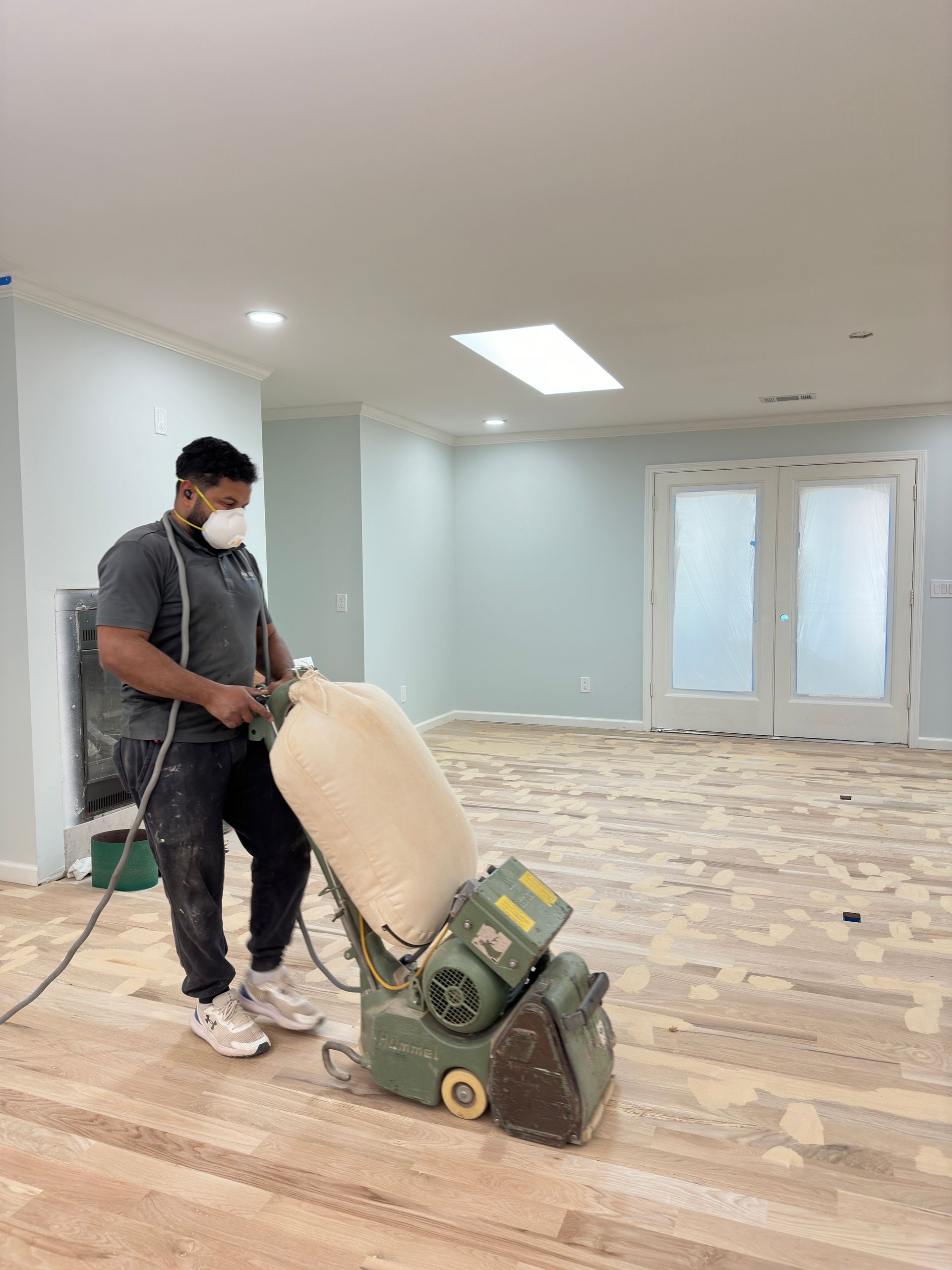 someone sanding a wooden floor in a home