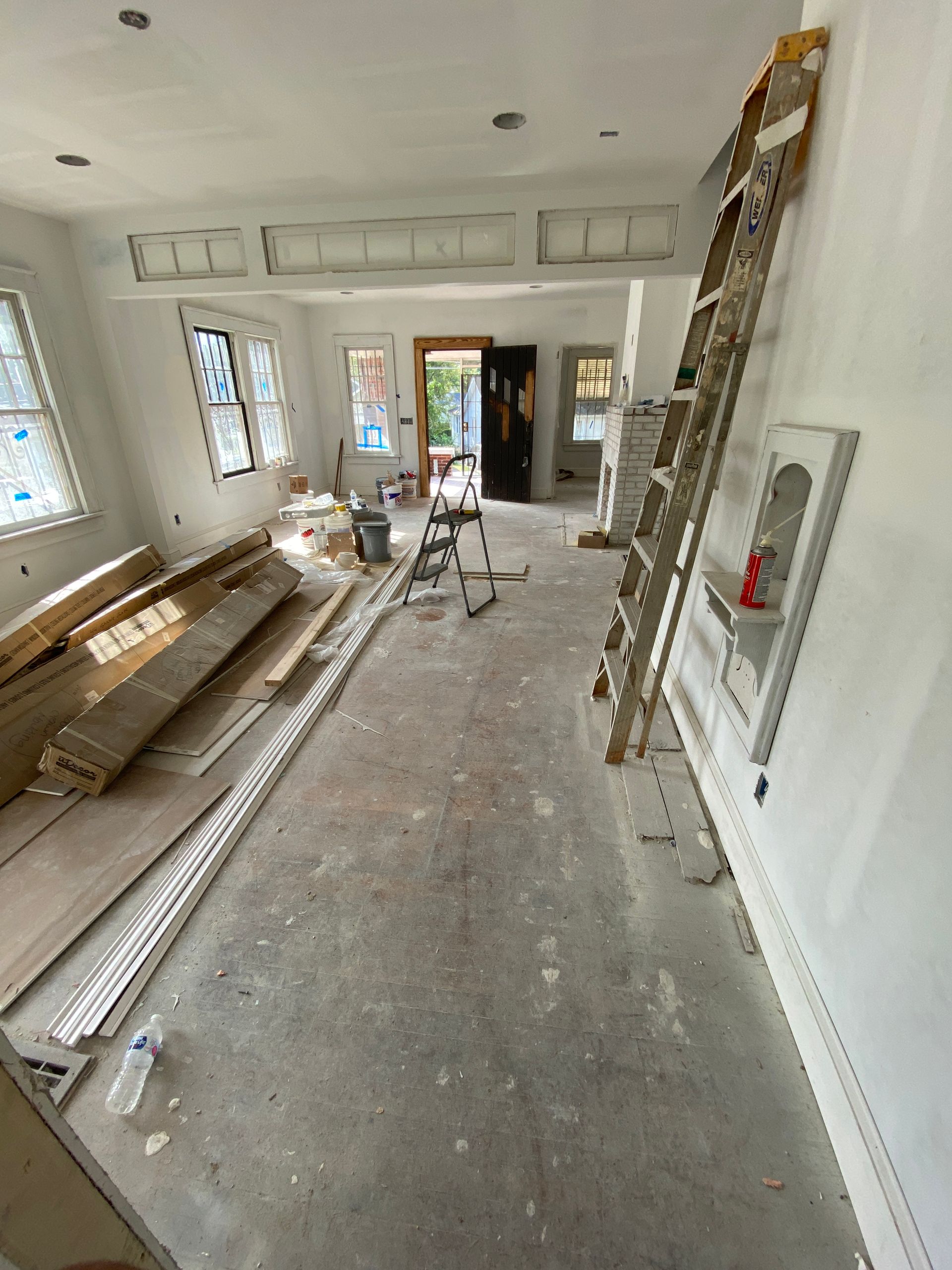 A living room with damaged hardwood 