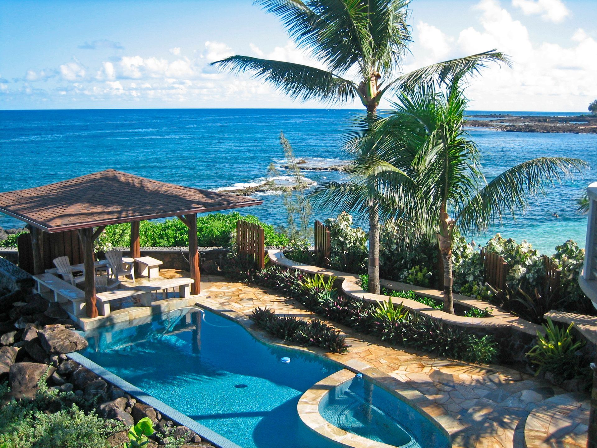 A lush green lawn with bushes and gravel in a garden.