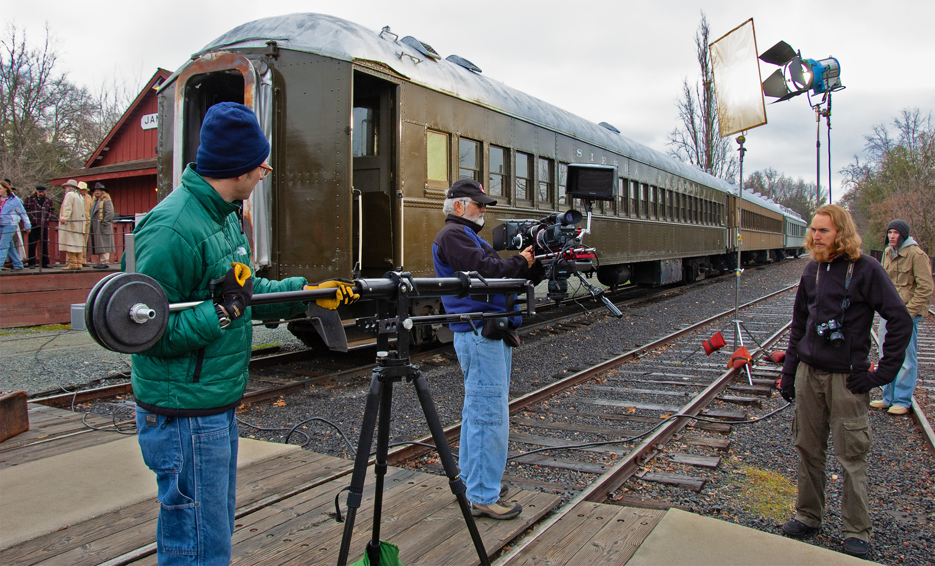A group of people are standing on a train track in front of a train