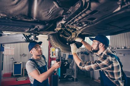 A man wearing white gloves is working on a brake disc.