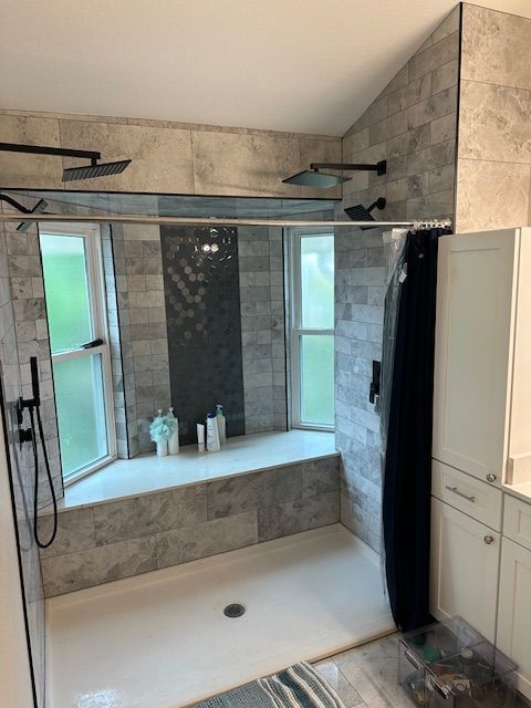 Modern bathroom with a walk-in shower, tiled walls, glass enclosure, and a built-in window ledge.