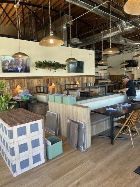 Modern café interior with a counter, hanging lights, and a person working behind the bar