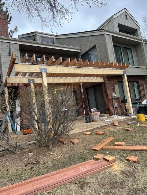 House under construction with a new wooden pergola and scattered lumber in the front yard