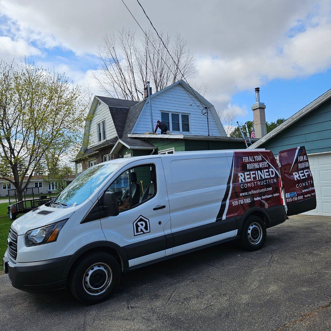 A white van is parked in front of a house.