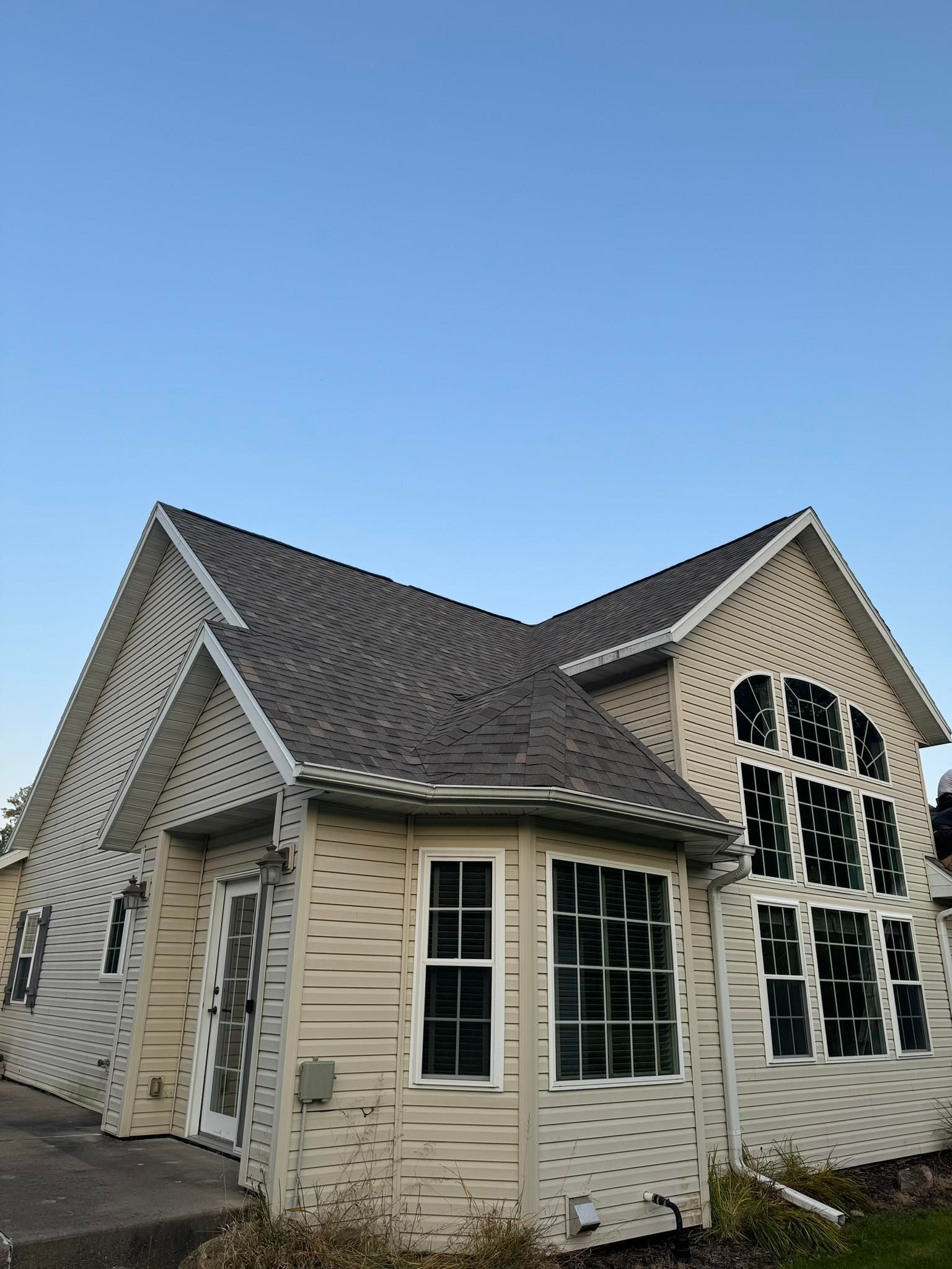 A white house with a gray roof and a blue sky in the background.
