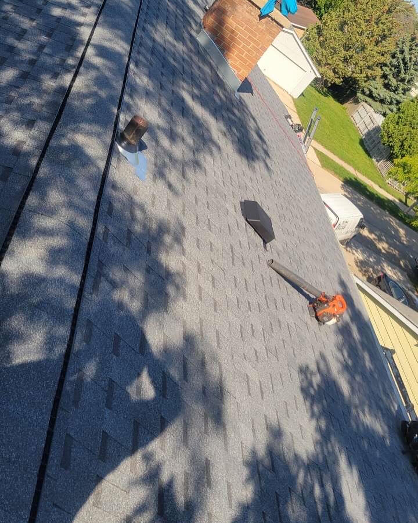 An aerial view of a roof with shingles being installed.