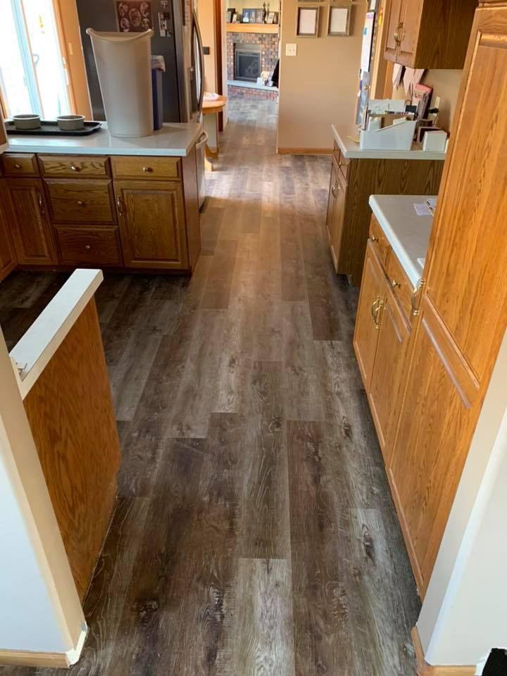 A kitchen with hardwood floors and wooden cabinets.