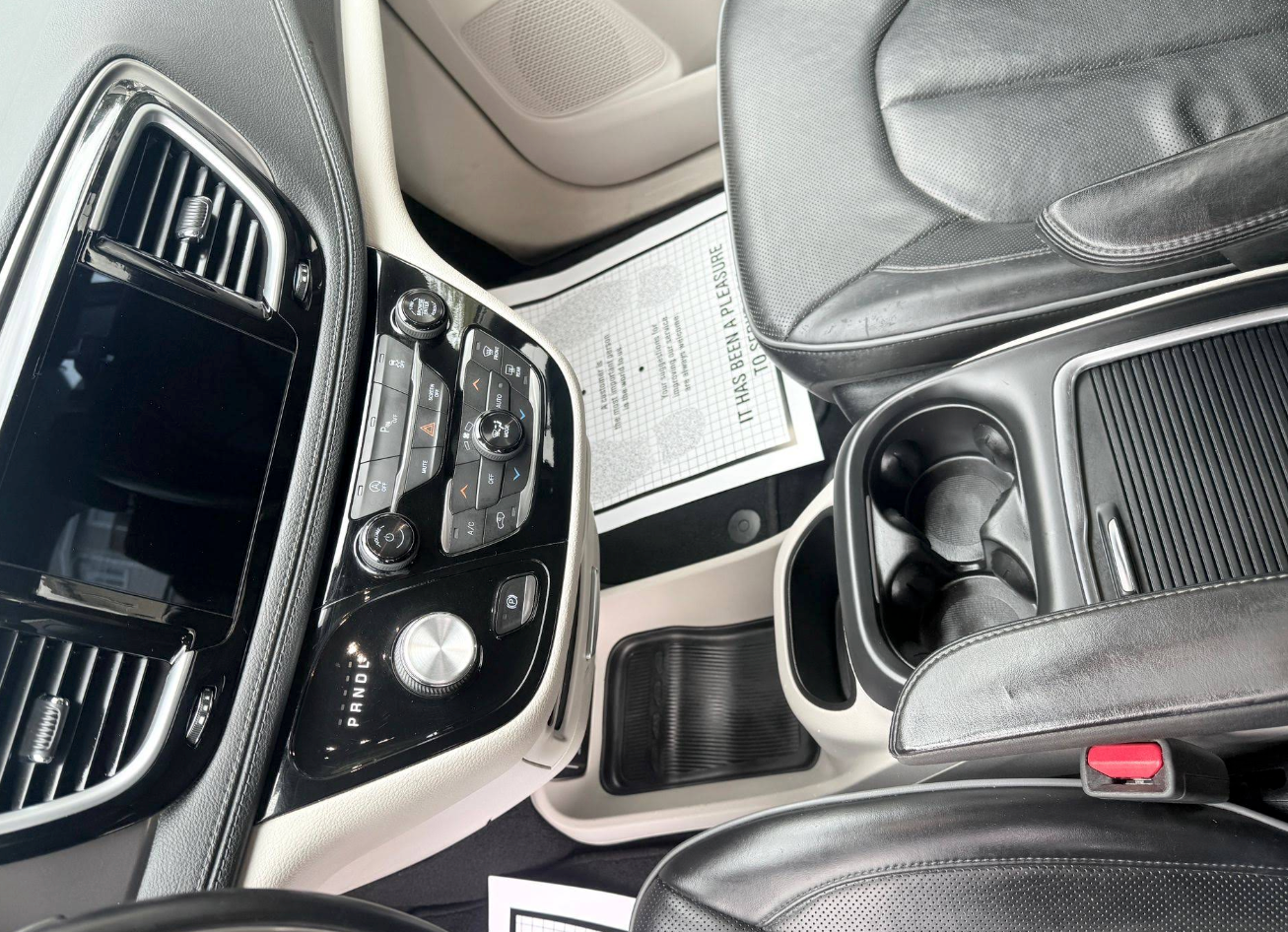Car interior with dashboard, console, cupholders, and black leather seats. | JR Car Care Inc