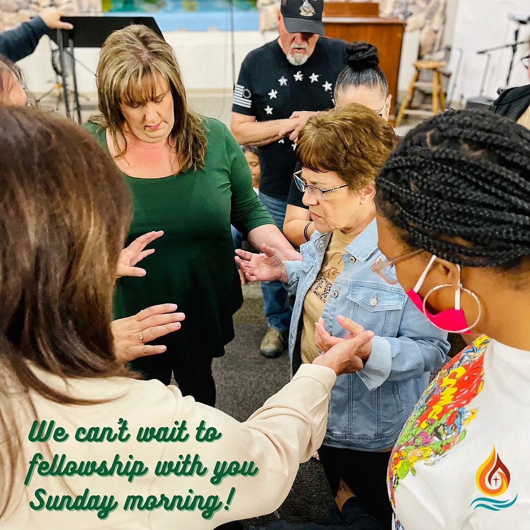 a group of people are standing in a room and talking to each other .