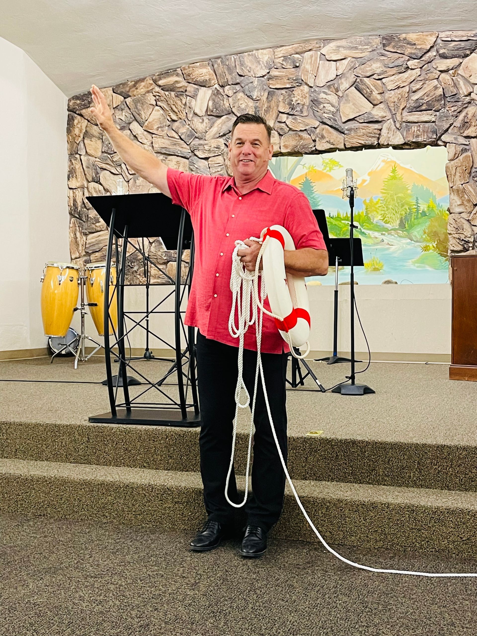 A man in a red shirt is holding a rope in his hand