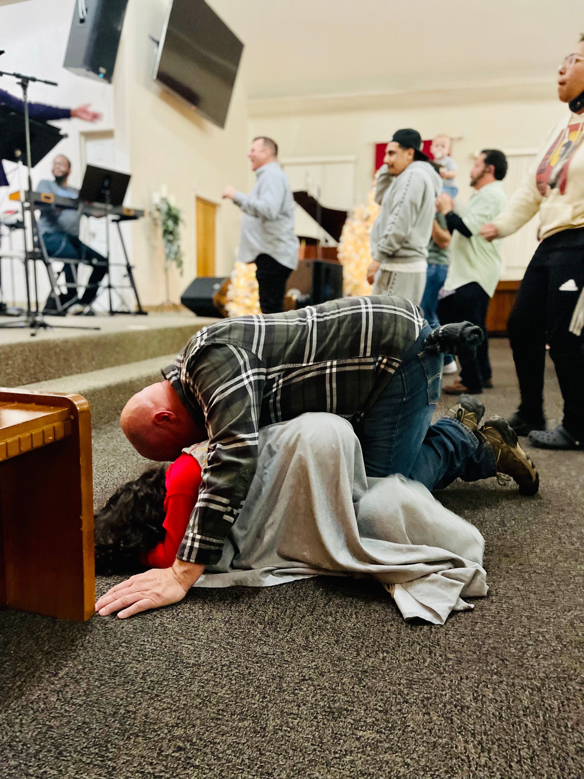A man is kneeling down in front of a group of people