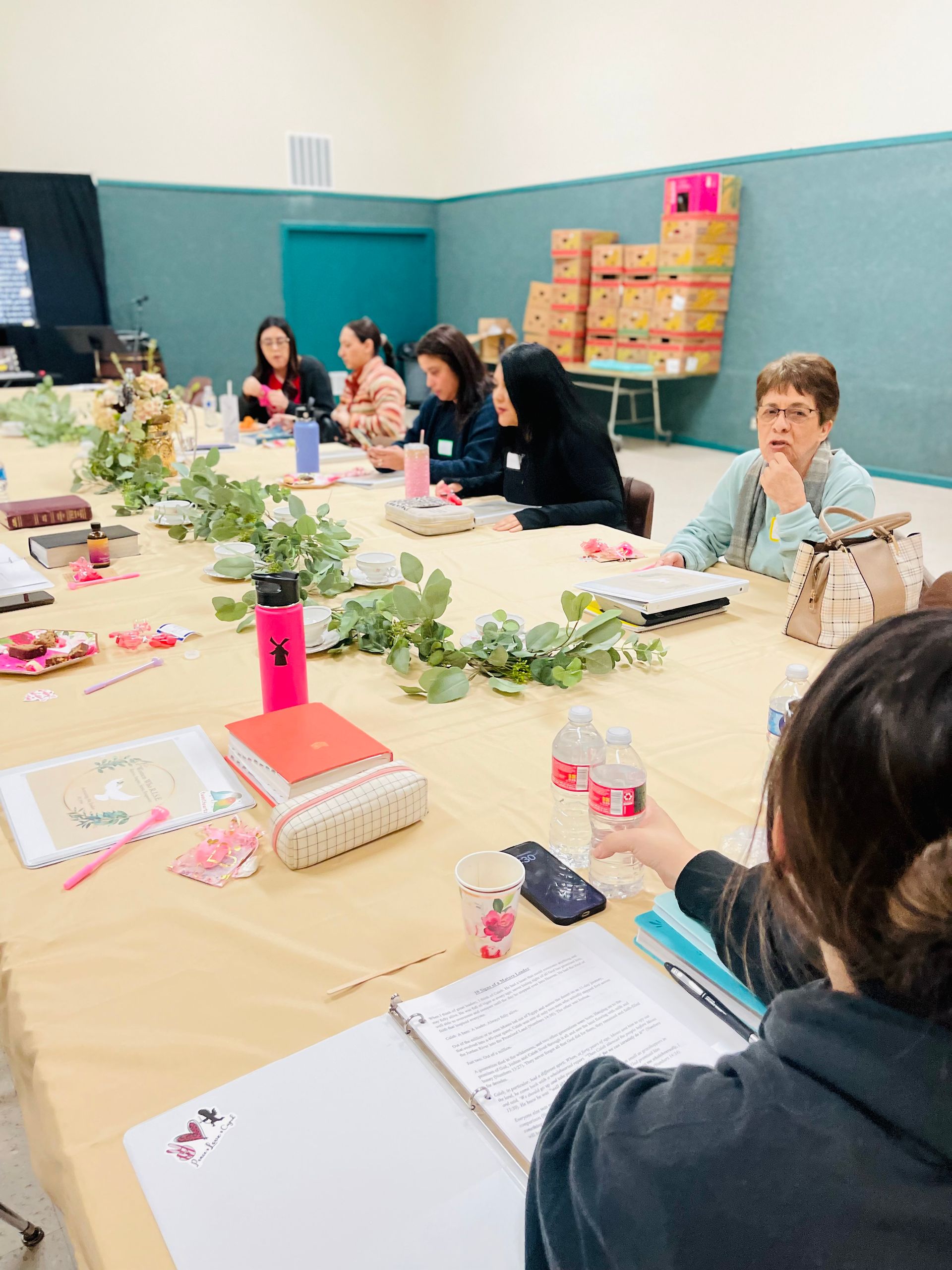 A group of people are sitting at a long table in a room.