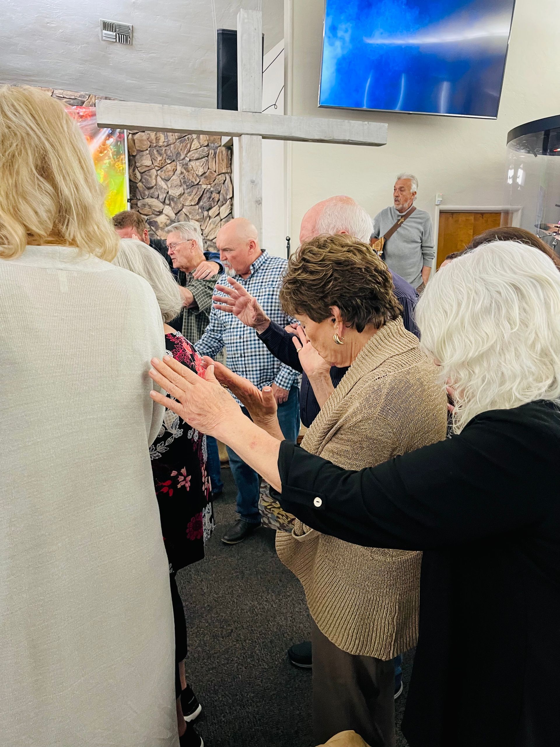 A group of people are standing in a room with their hands in the air.