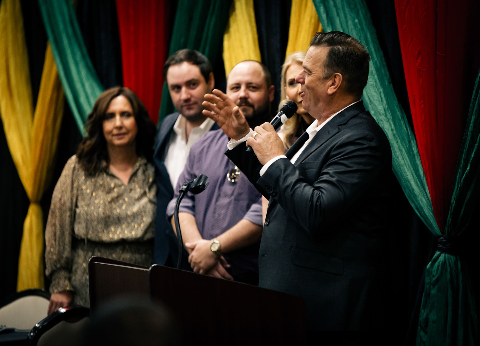 A man is standing at a podium giving a speech to a group of people.