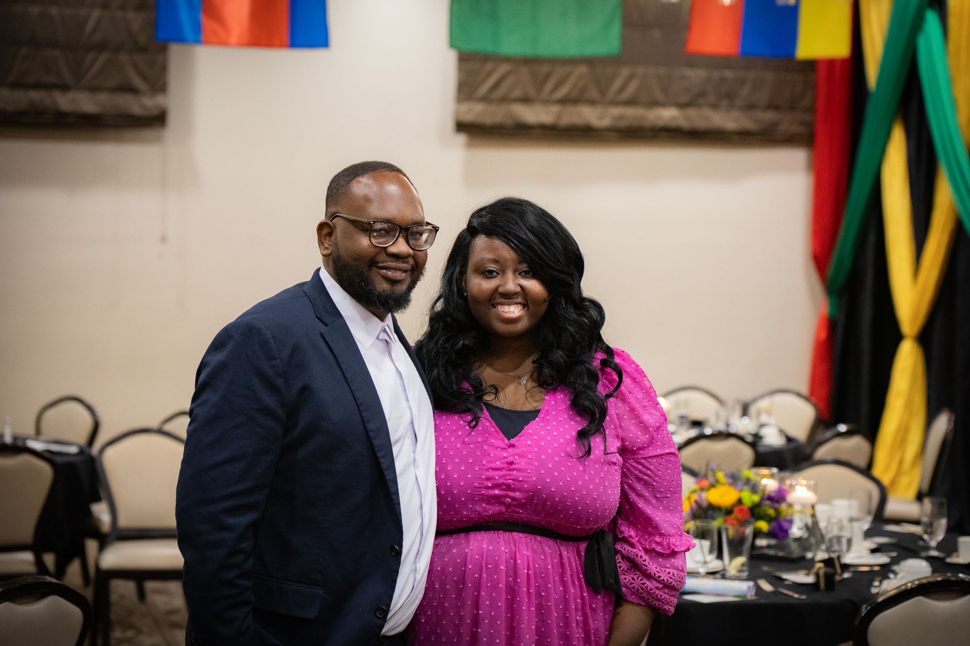 A man and a woman are posing for a picture in a room.