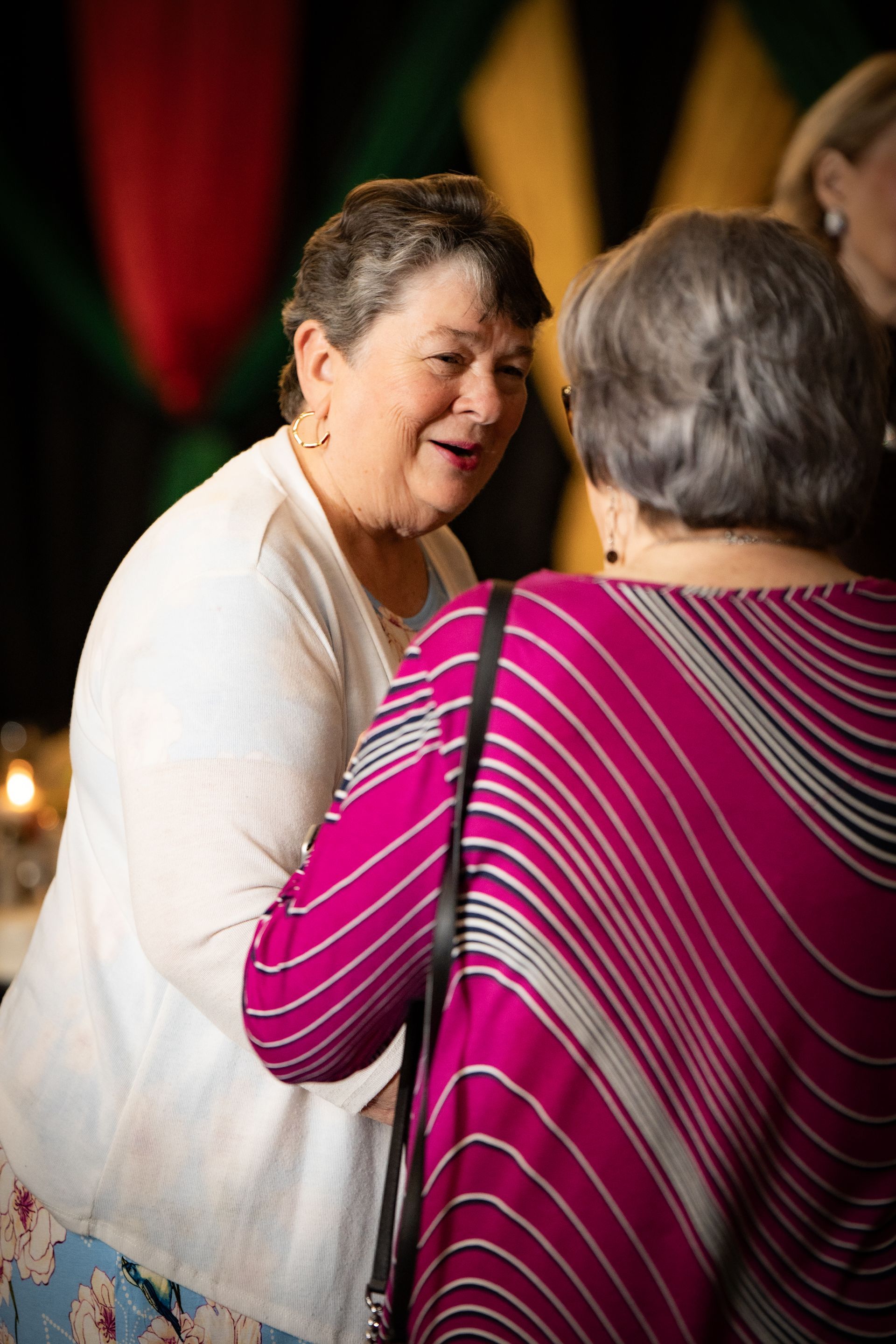 Two women are talking to each other in a dark room.