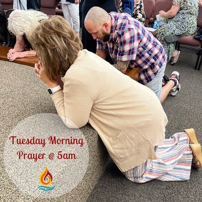 a man and a woman are kneeling down and praying in a church .