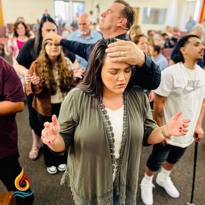 a group of people are standing in a room with their hands outstretched .