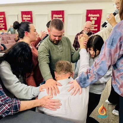 a group of people are praying together in a church .