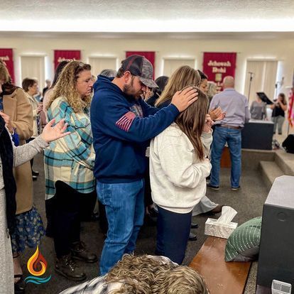 a group of people are praying together in a church .