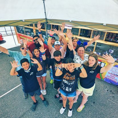a group of people are posing for a picture with their hands in the air .