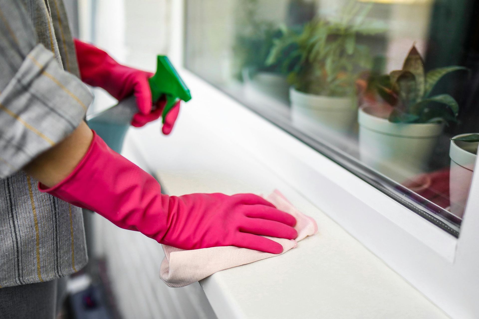 A man in a protective suit is cleaning a living room.
